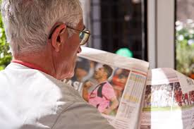 Persona mayor leyendo el periódico.