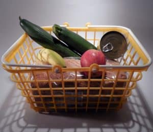 Foto de una cesta con frutas verduras y pan.