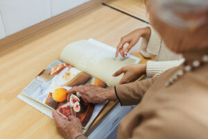 Abuela y cuidadora viendo un libro de recetas