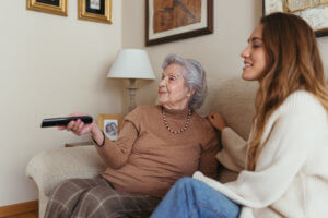 Abuela y cuidadora viendo una película en el sofa
