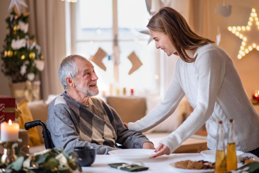 Hiporexia Cuidador y anciano sonrientes en el salón con el plato de comida vacío.