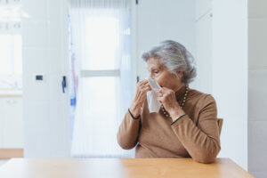 Anciana sonándose debido a acumulación de mocos por neumonía