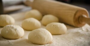 Panecillos redondos junto a rodillo.