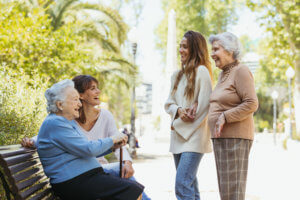 Cuidadoras y ancianas en el parque riendose