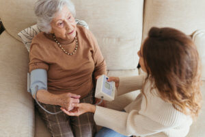 Cuidadora midiéndole la tensión a la abuela