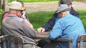 Abuelos jugando a un juego de mesa en el parque.