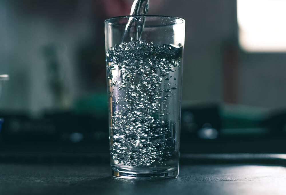 Agua siendo vertida en un vaso de cristal.