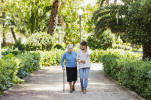 Abuela y cuidadora caminando por el parque ribalta