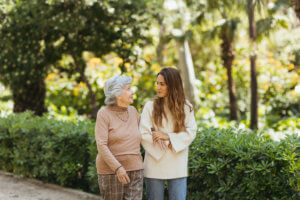 Abuela y cuidadora caminando por el parque