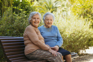 Dos abuelas sentadas en un banco del parque