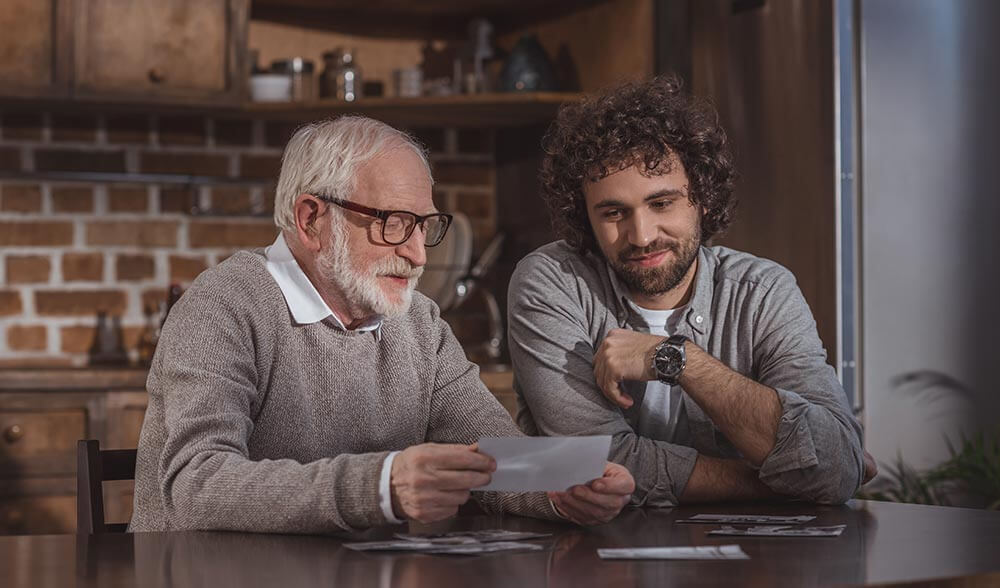 Padre lee unas frases del día del padre que su hijo le ha escrito, quien está a su lado.