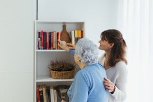 Abuela y cuidadora mirando que libro escoger de la estentaria