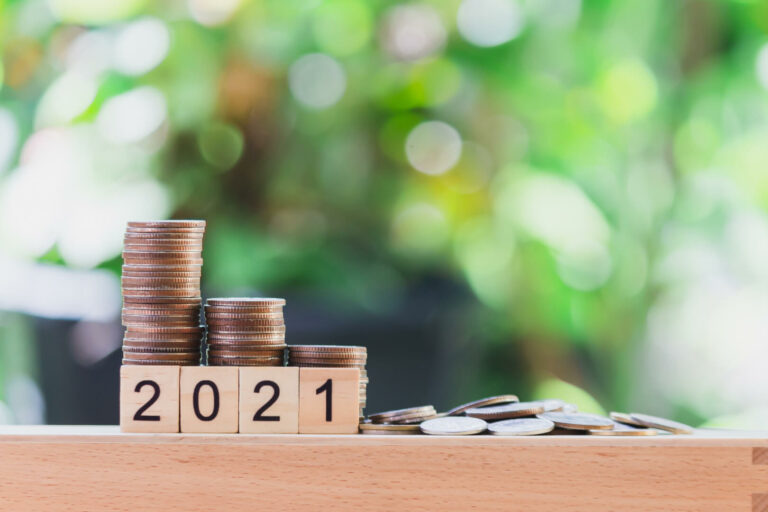 Monedas sobre cubos de madera que dicen 2021.