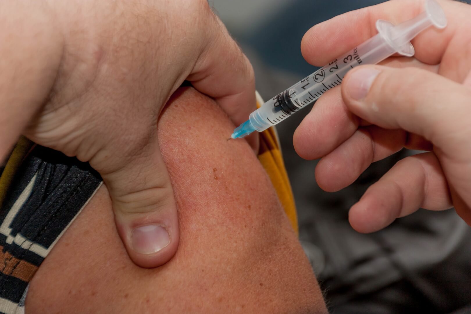 En la imagen se muestra el pinchazo en plano detalle, de una vacuna, en este caso contra la gripe, como una solución eficaz para evitar sufrir de bronconeumonía. 