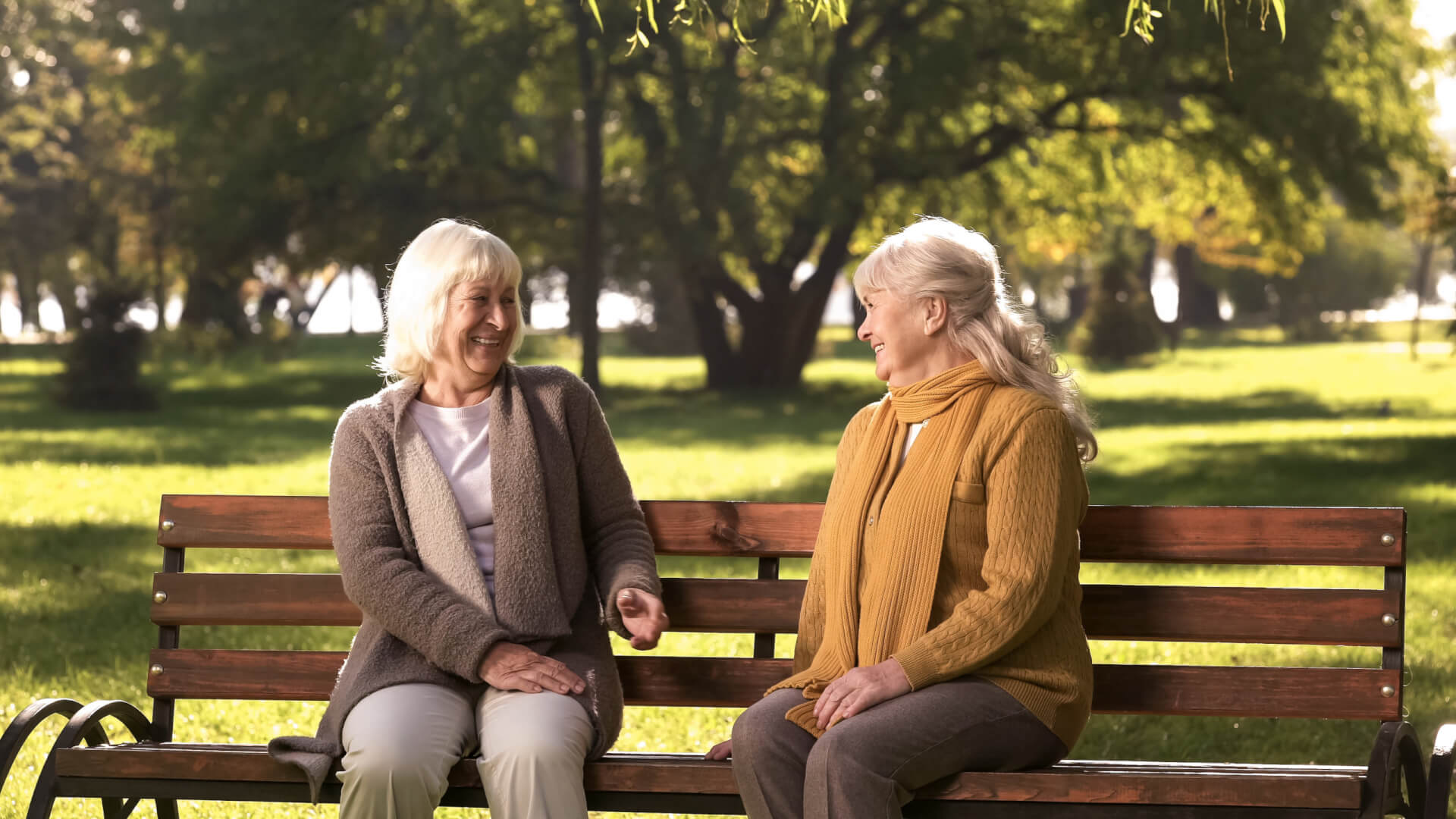 Se muestra dos mujeres mayores sentadas en un banco en una ciudad inglesa, en los llamados chattie benches, otra de las iniciativas sociales para combatir la soledad. 