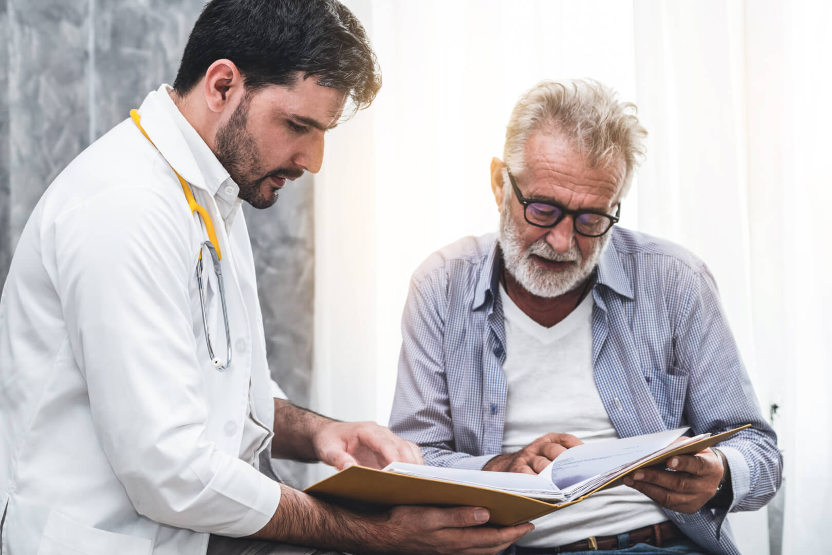 En la imagen se muestra un médico mostrando los resultados de la prueba de detección del cáncer a una persona mayor