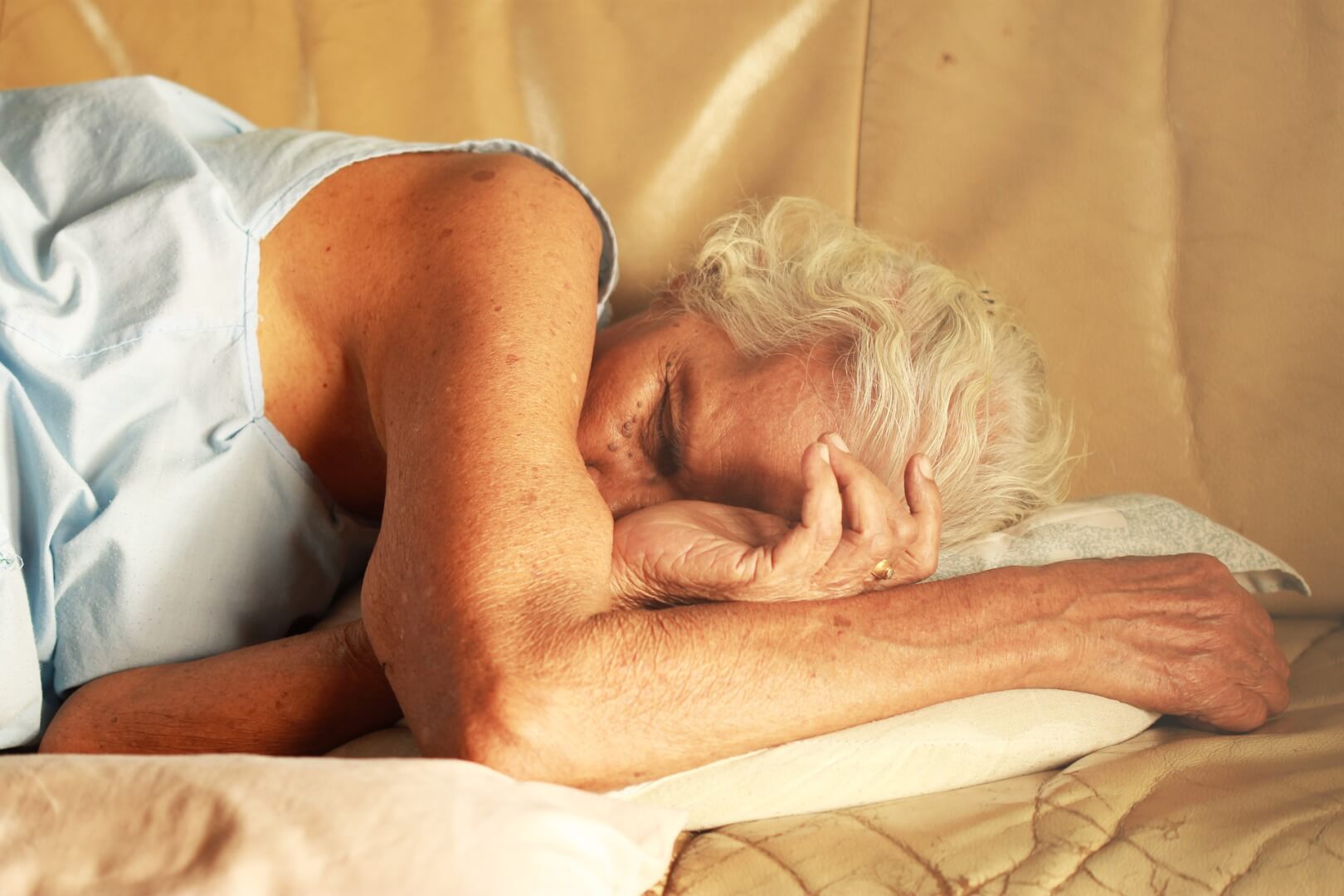 Una mujer mayor durmiendo la siesta para recuperarse de la energía de la mañana en el sofá de su casa. 