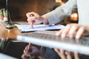 Persona con un cuño sobre unas hojas aprobando la nueva bajada de impuestos en la Comunidad de Madrid