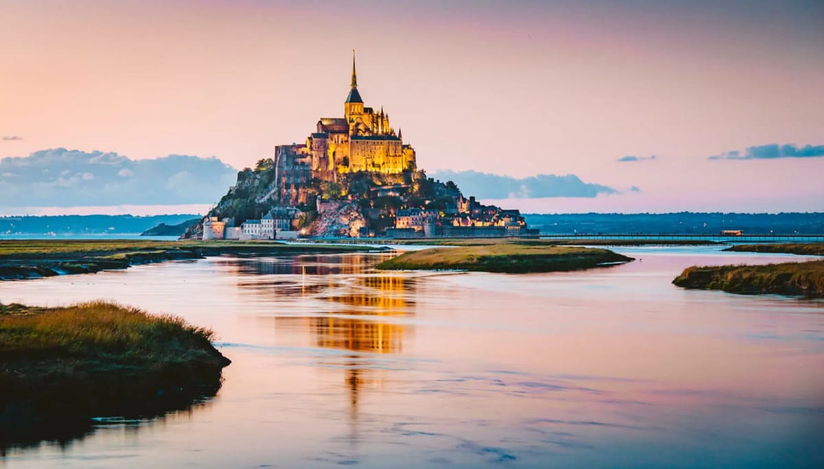 Se muestra el castillo de Normandía en Francia bajo un atardecer.