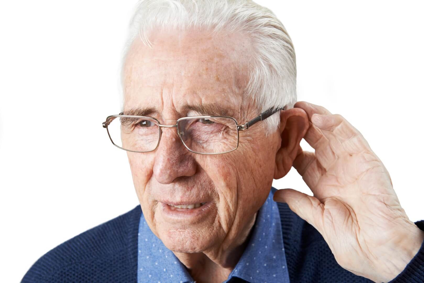Un hombre mayor con gafas se queja de un dolor en el oído mientras que palpa la parte de detrás del mismo.