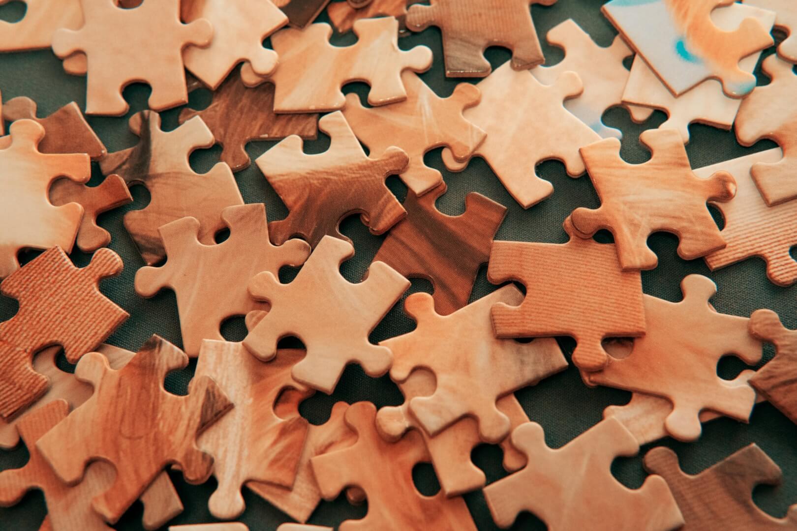Una imagen de un puzzle con piezas de madera desordenadas.