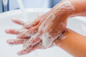 Primer plano de unas manos enjabonadas: TOC por la limpieza