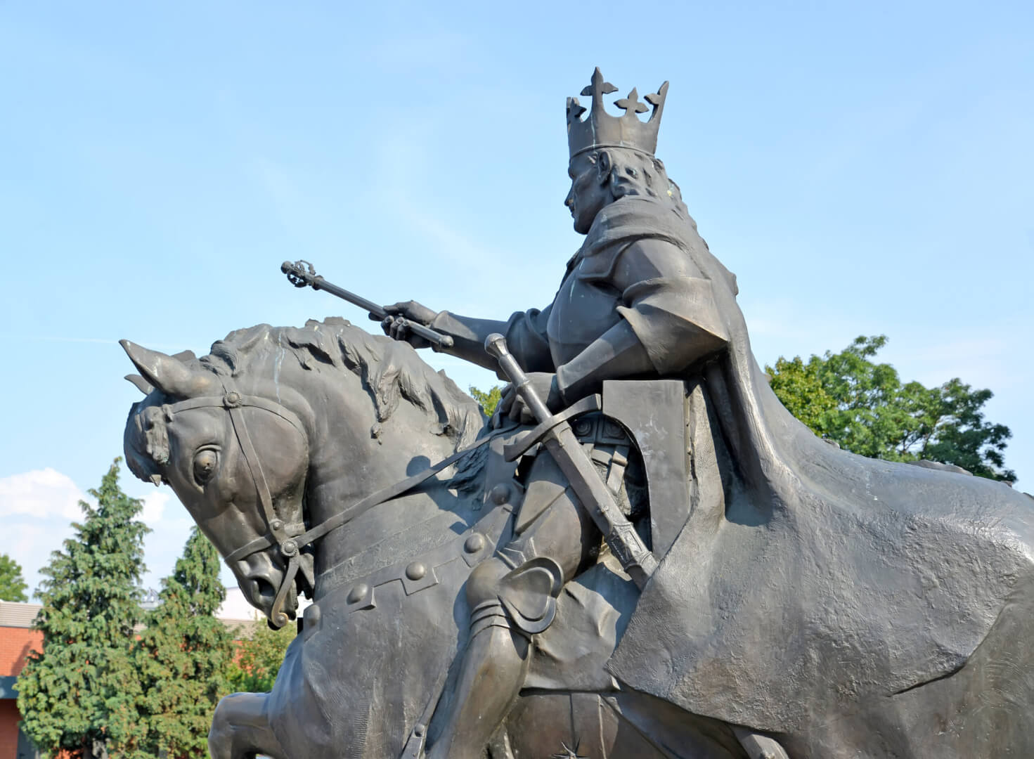 Una estatua de un antiguo emperador subido a un caballo mientras sostiene un bastón de mando.
