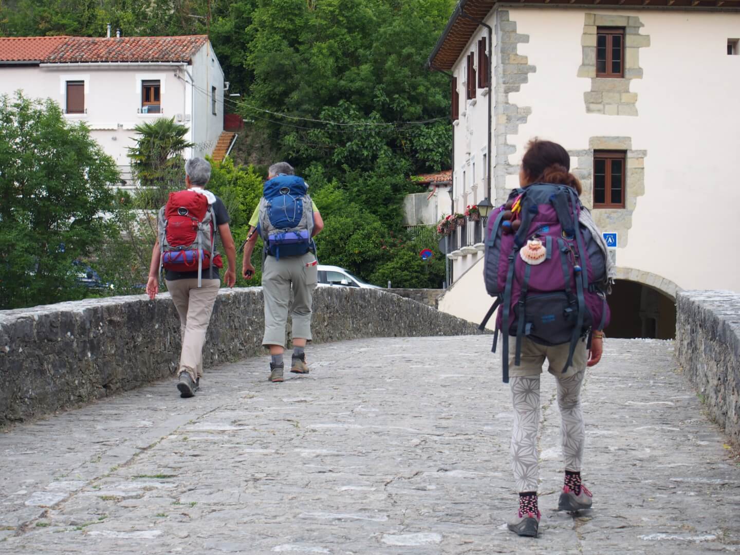 Unos peregrinos caminan por un puente en una ruta del Camino de Santiago