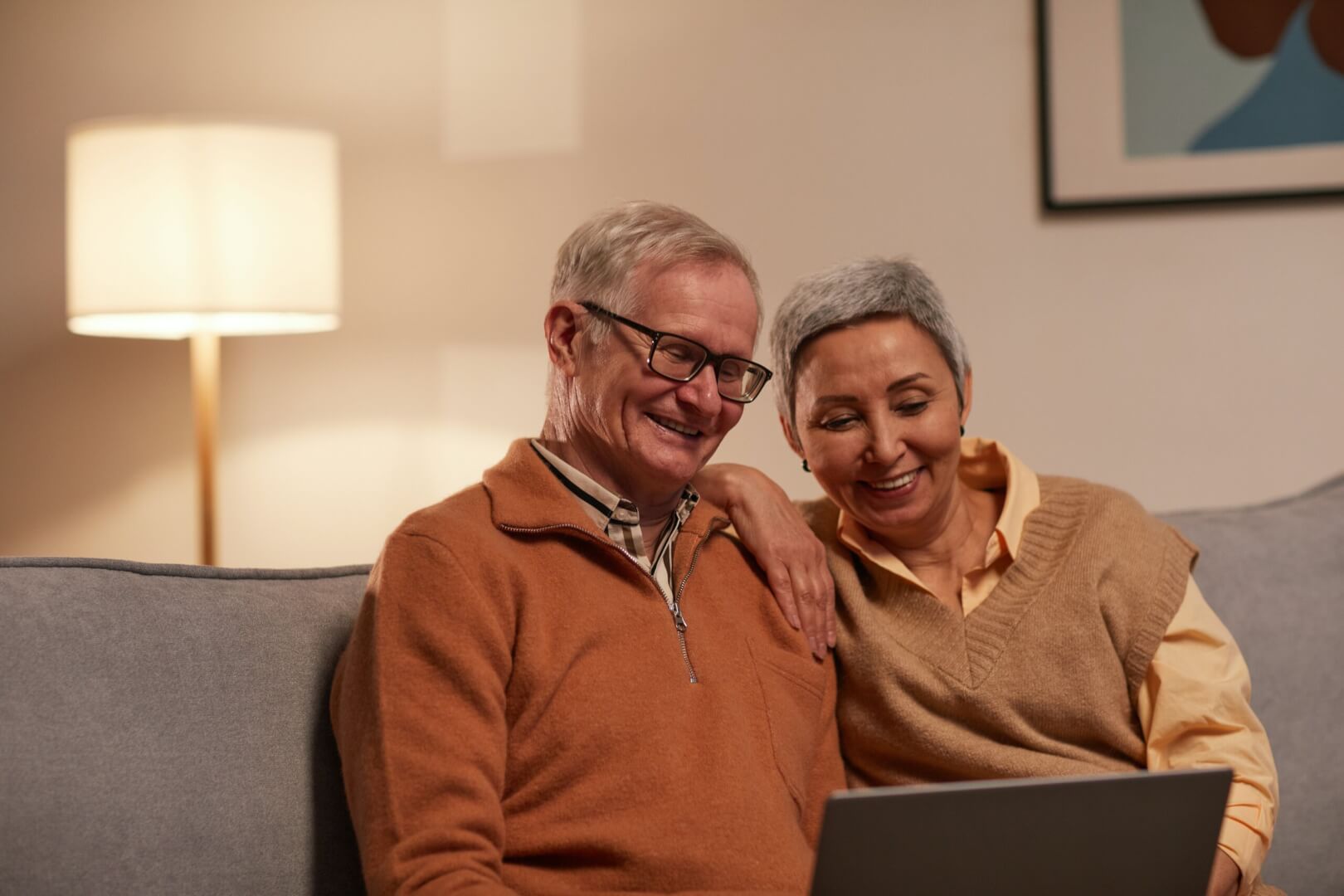 Dos ancianos se ríen viendo un vídeo en el ordenador.