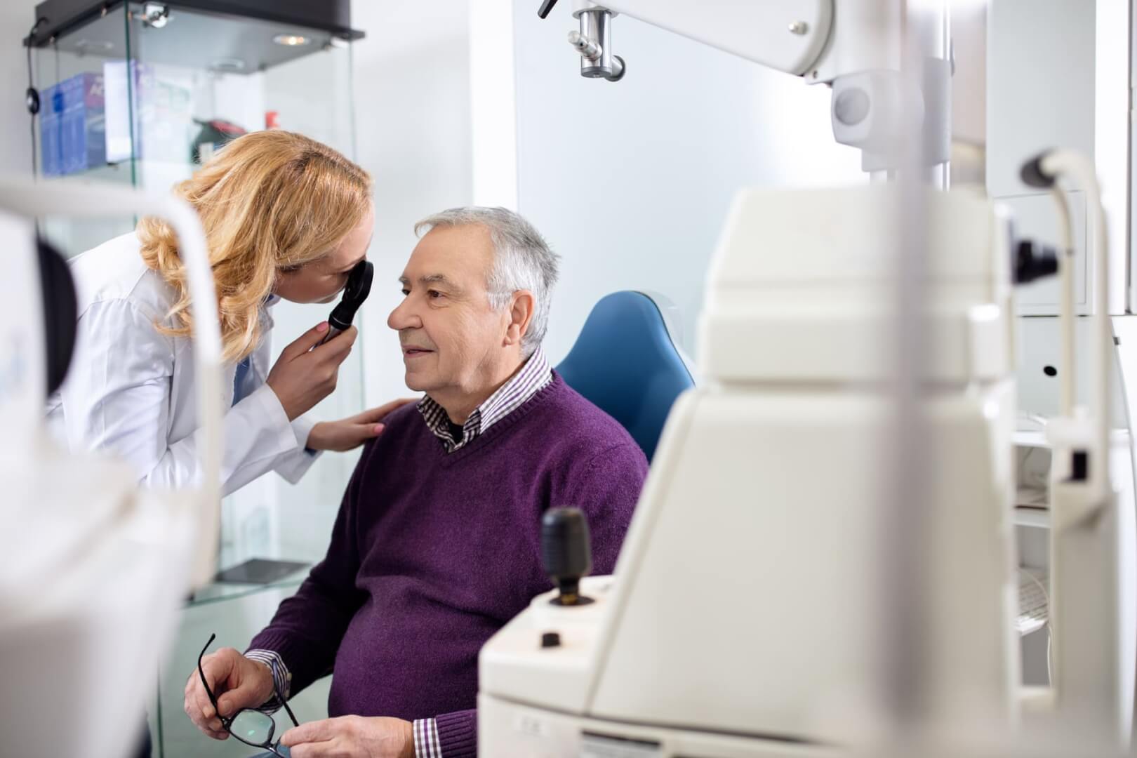 Una médico examina la salud ocular de un hombre mayor.