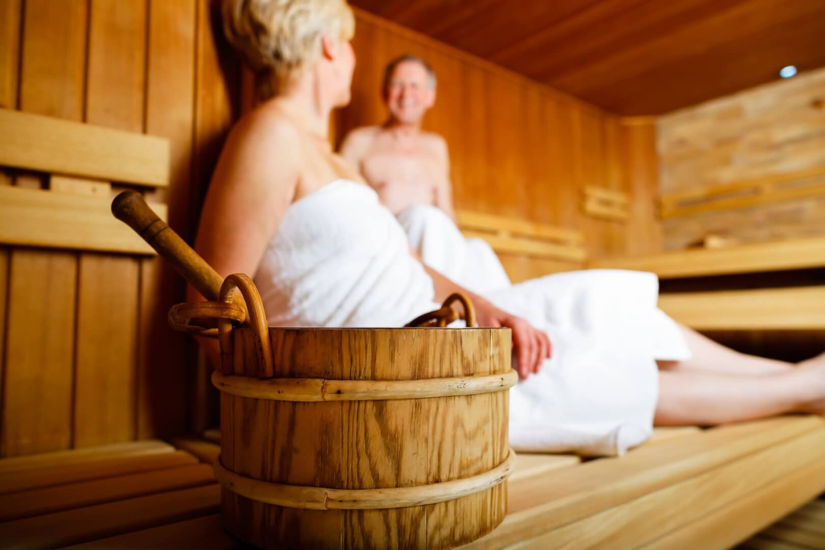 Dos personas mayores sentados en una sauna.