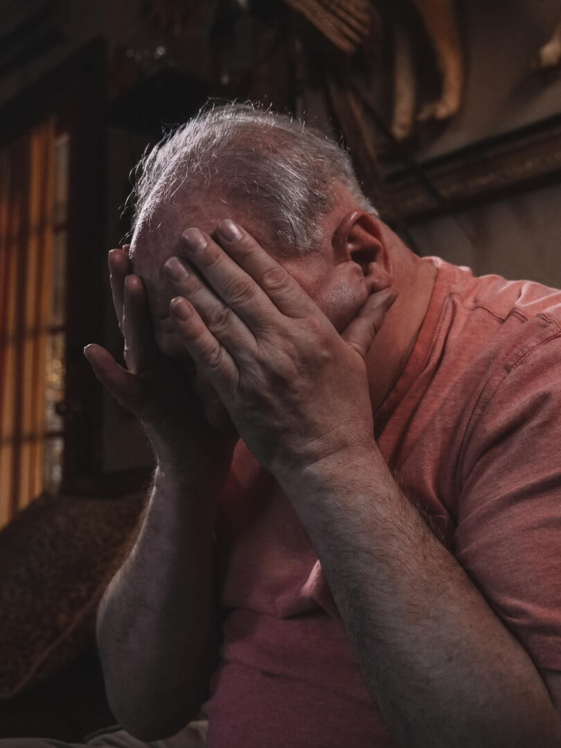 Un anciano se coloca las manos en la cabeza en claro síntoma de estrés. 