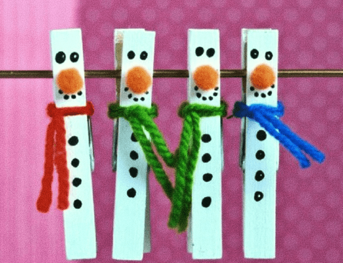 Unas pinzas de la ropa reconvertidas en muñecos de nieve, con sus caras y bufandas de colores. 