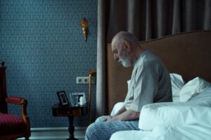 Hombre mayor sufre de soledad no deseada y permanece sentado en la cama