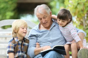 Abuelo leyendo un libro con sus nietos