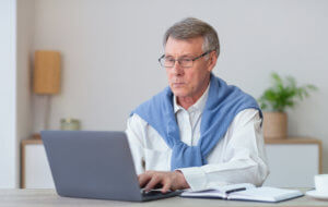 Persona mayor con un ordenador emprendiendo