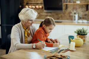 Abuela y niña coloreando un cuaderno