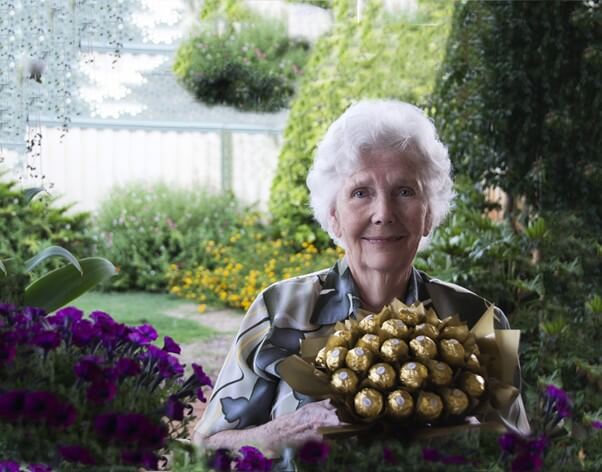 Abuela feliz con una bandeja de bombones
