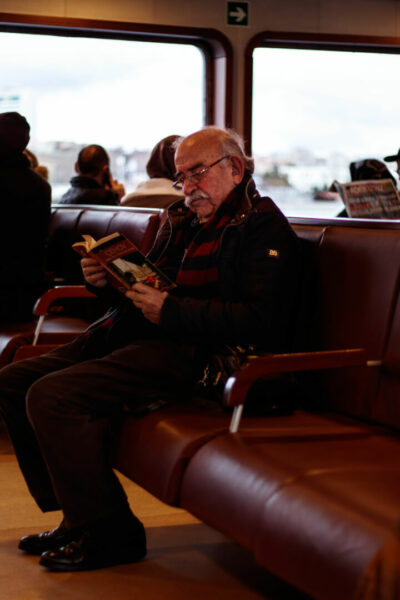 Un anciano lee un libro mientras está esperando un avión en el aeropuerto.