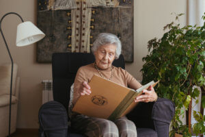 Abuela mirando un álbum en el salón