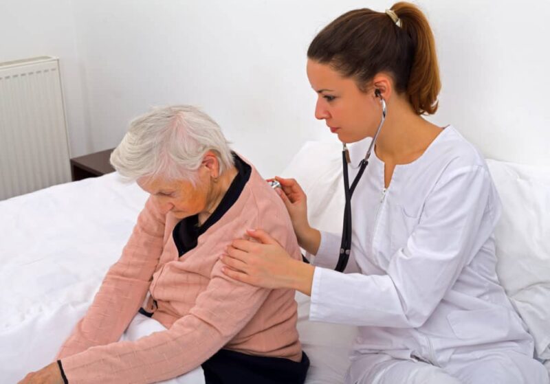 Mujer mayor con un medico auscultándole en busca de síntomas de neumonía. 