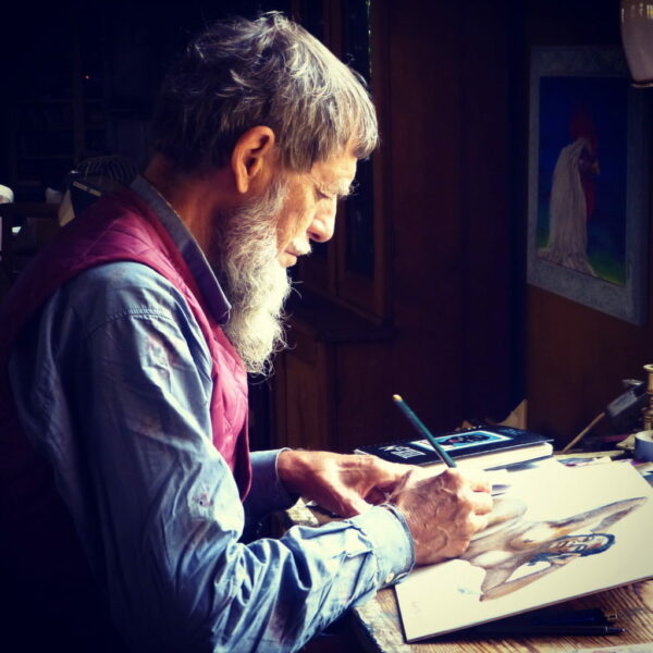 Hombre mayor con pincel y espátula pintando un lienzo. 