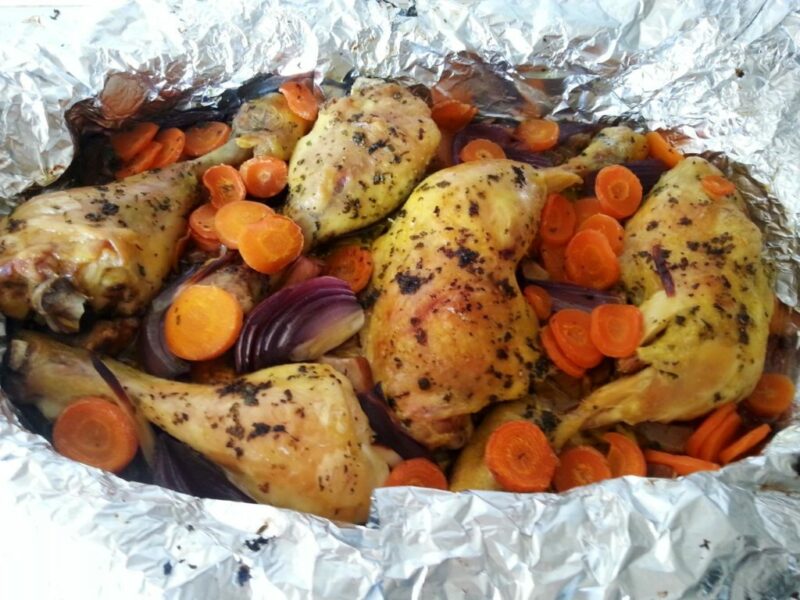 Imagen del plato finalizado de muslitos de pollo en papillote con verduras. 