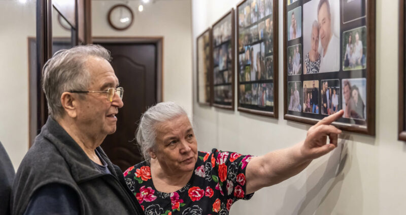 Anciano enseña a su marido fotografías de su juventud