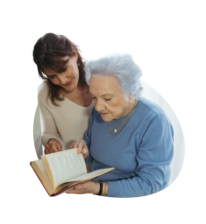 Mujer joven y señora mayor leen un libro.