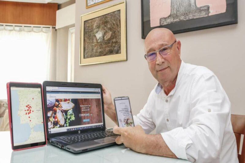 Francisco Solano dueño de Comer Sano enselando su móvil con la app y el ordenador con la web de la empresa