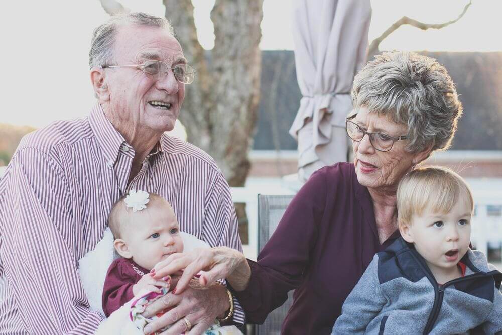 Una pareja de ancianos posando con sus nietos. 