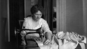 Fotografía antigua de una mujer cosiendo a máquina.