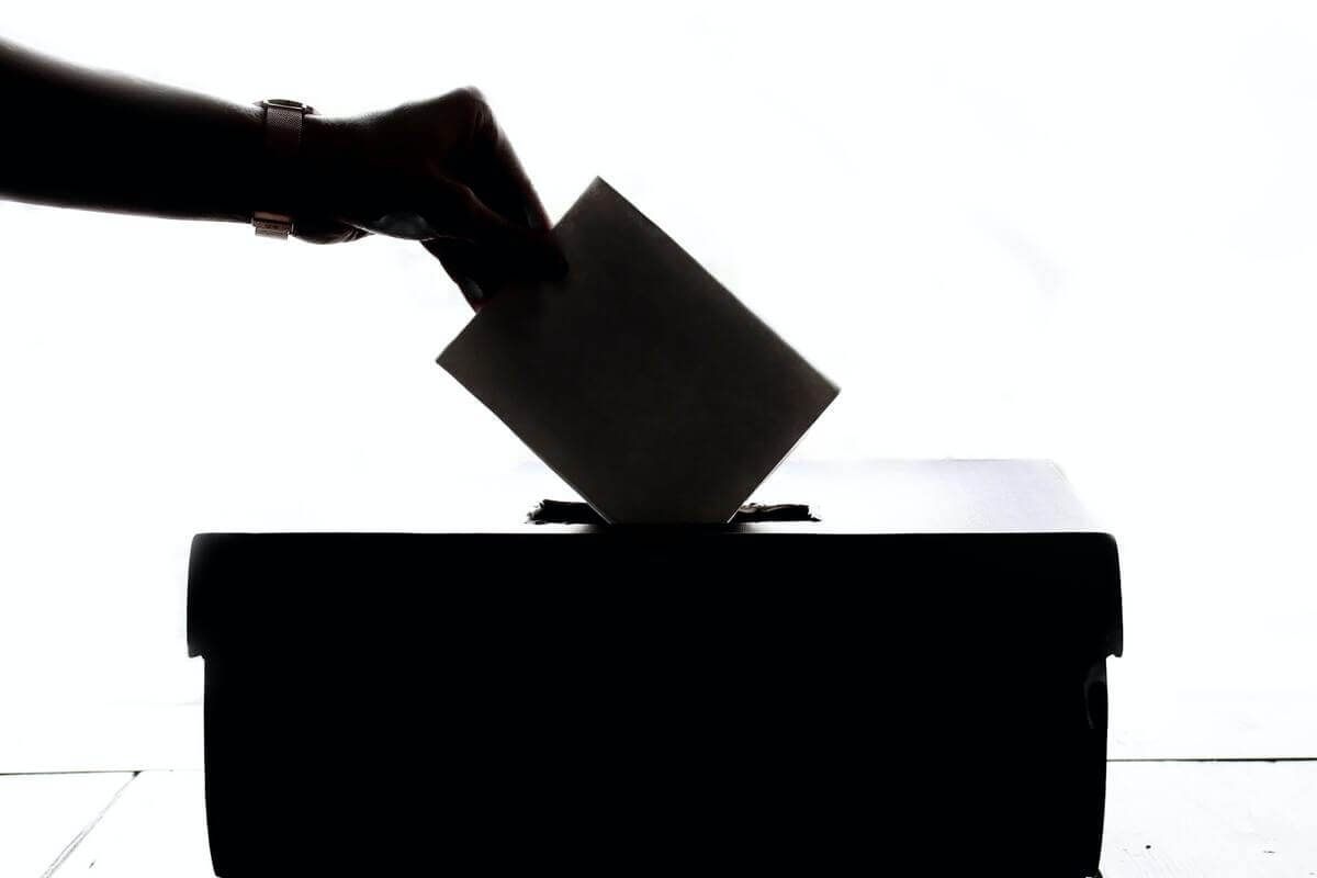 Una persona poniendo su voto en una urna