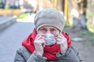 Una mujer mayor mira a cámara mientras porta una mascarilla FFP2.